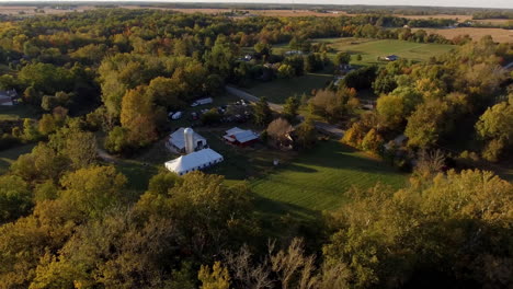 toma aérea del lugar de la boda al aire libre en una zona rural con colores otoñales, toma cinematográfica de drones giratorios