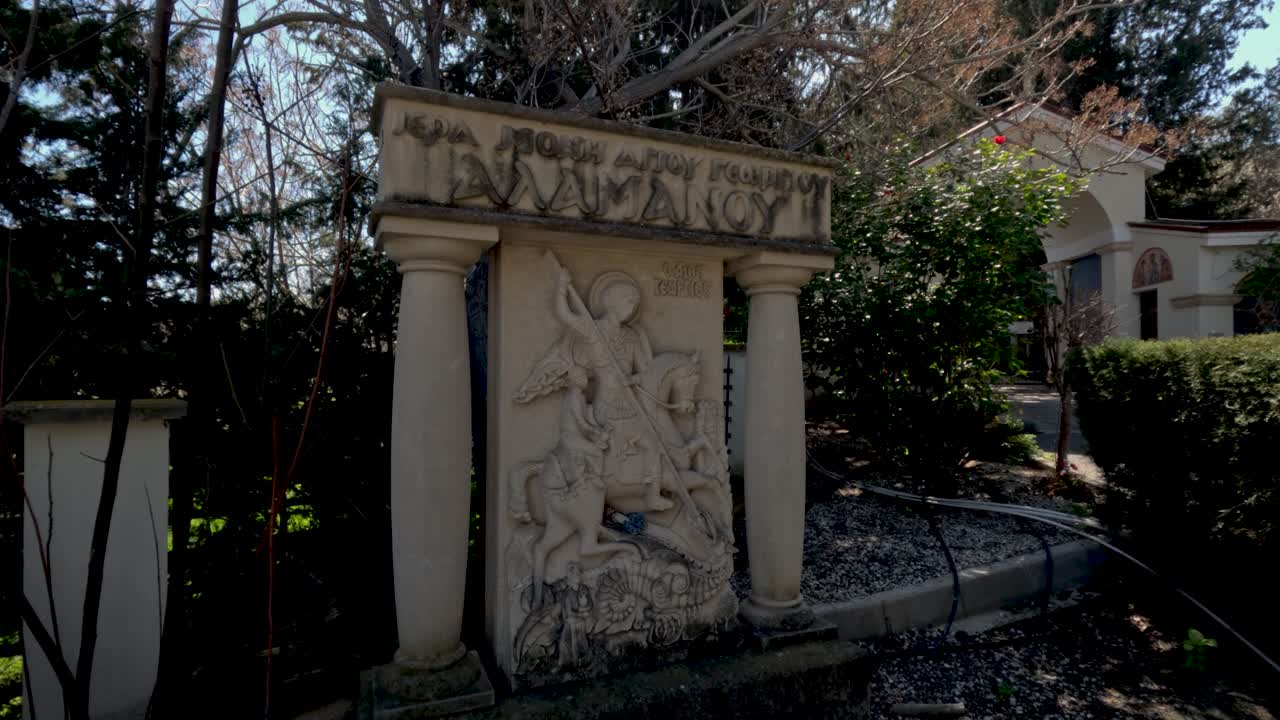 Persone camminano in un parco che presenta arte e verde. Il luogo ha alberi e piante. I visitatori possono rilassarsi e godere della bellezza circostante. È una giornata di sole con cielo sereno