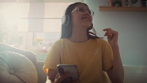 caucasian teenage girl wearing headphones and listening music from her phone