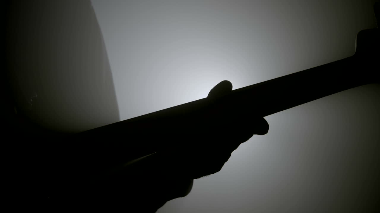 Silhouette of a man playing bass