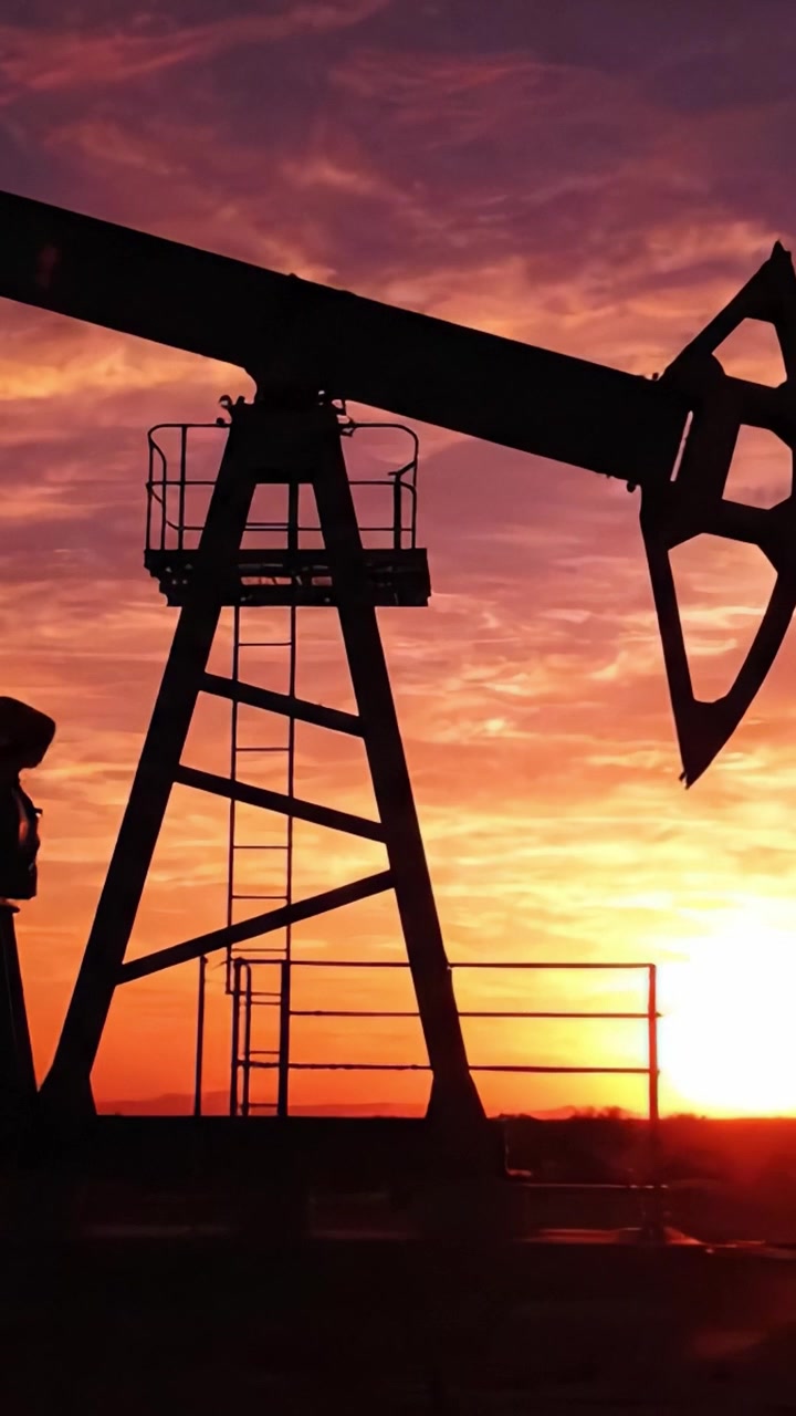 Sunset Silhouette of an Oil Pump Jack Against a Vibrant Sky, Illustrating the Intersection of Nature and Industry in an Energy Landscape