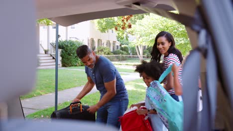 Familie-Reist-In-Den-Urlaub-Und-Lädt-Gepäck-Ins-Auto