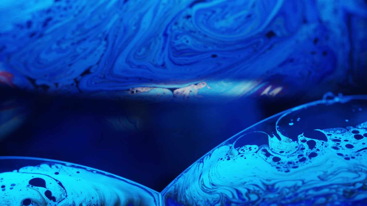 Ripresa macro di vortici blu e belle linee dalla superficie di una soluzione liquida.