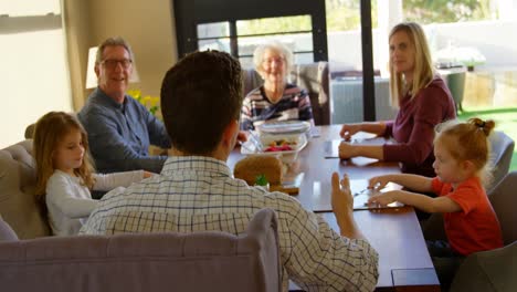 familia de varias generaciones interactuando entre sí en la mesa de comedor 4k