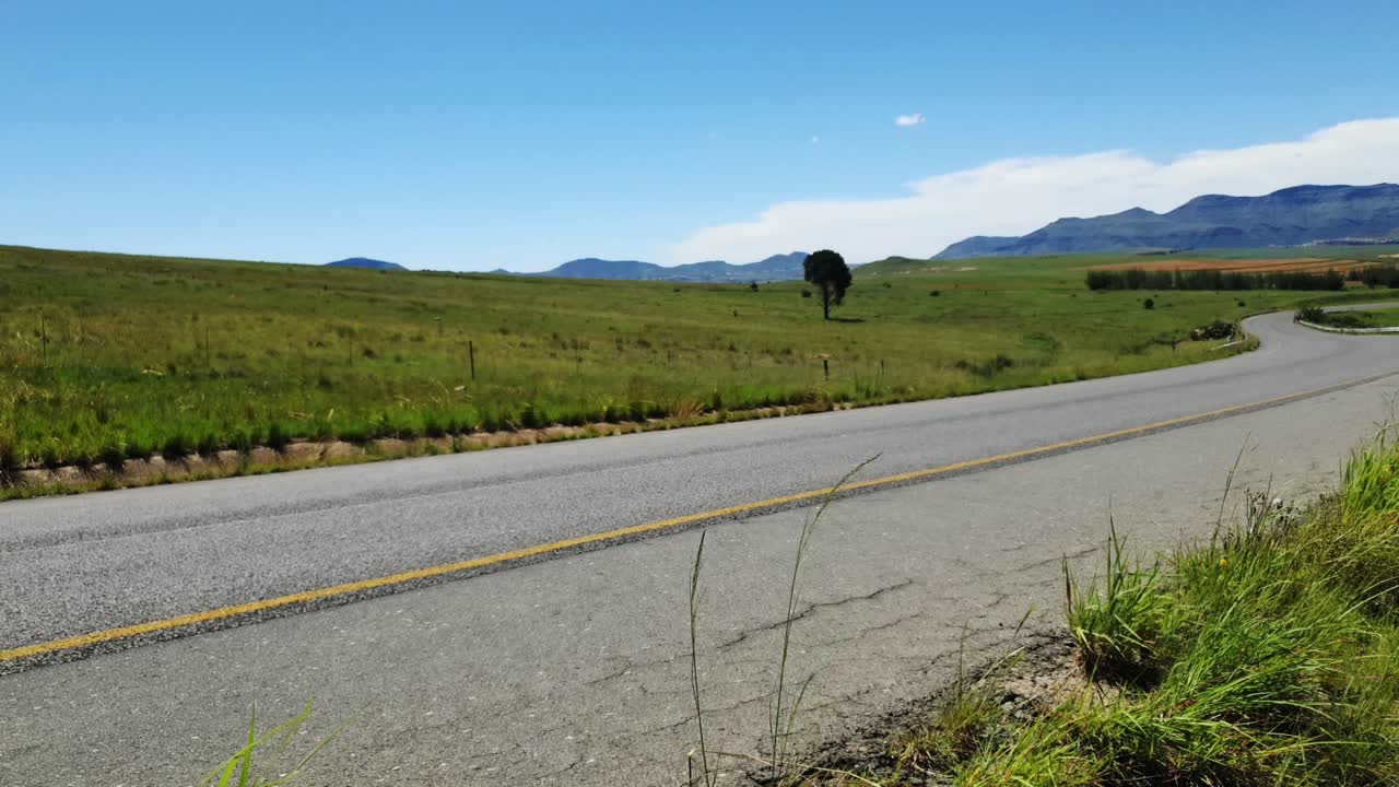 R711 road outside Clarens town in Free-state province South Africa with cars and motorbike traffic traveling past on vacation in Moluti Mountains.