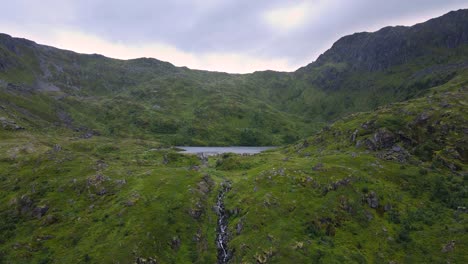 Flying-towards-a-reservoir-and-cascading-water-in-the-saddle-of-a-Norwegian-mountain