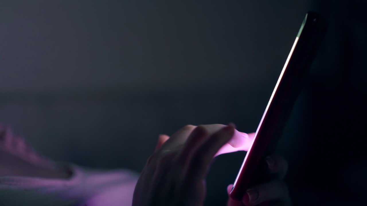 persona in top rosa bugie e tipi su smartphone sottile