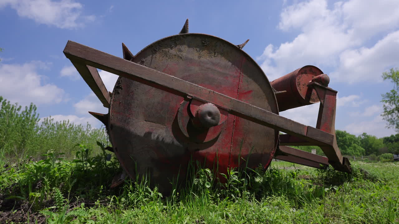Rusty antique farming machine abandoned in rural farmland, countryside landscape