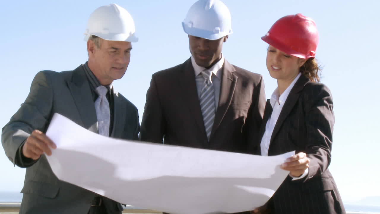 Three architects discussing a blueprint plan