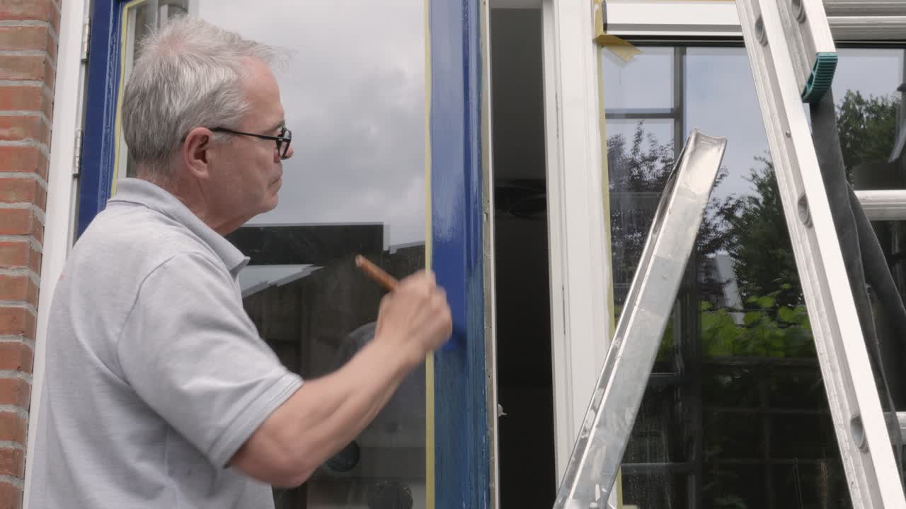 Man Painting a Window Frame