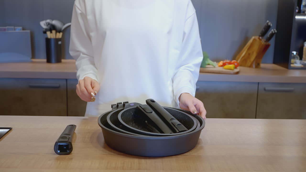 Woman preparing food with cookware set in a modern kitchen