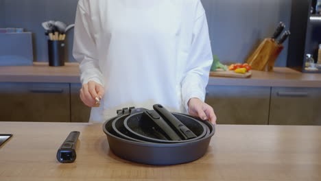 woman preparing food with cookware set in a modern kitchen