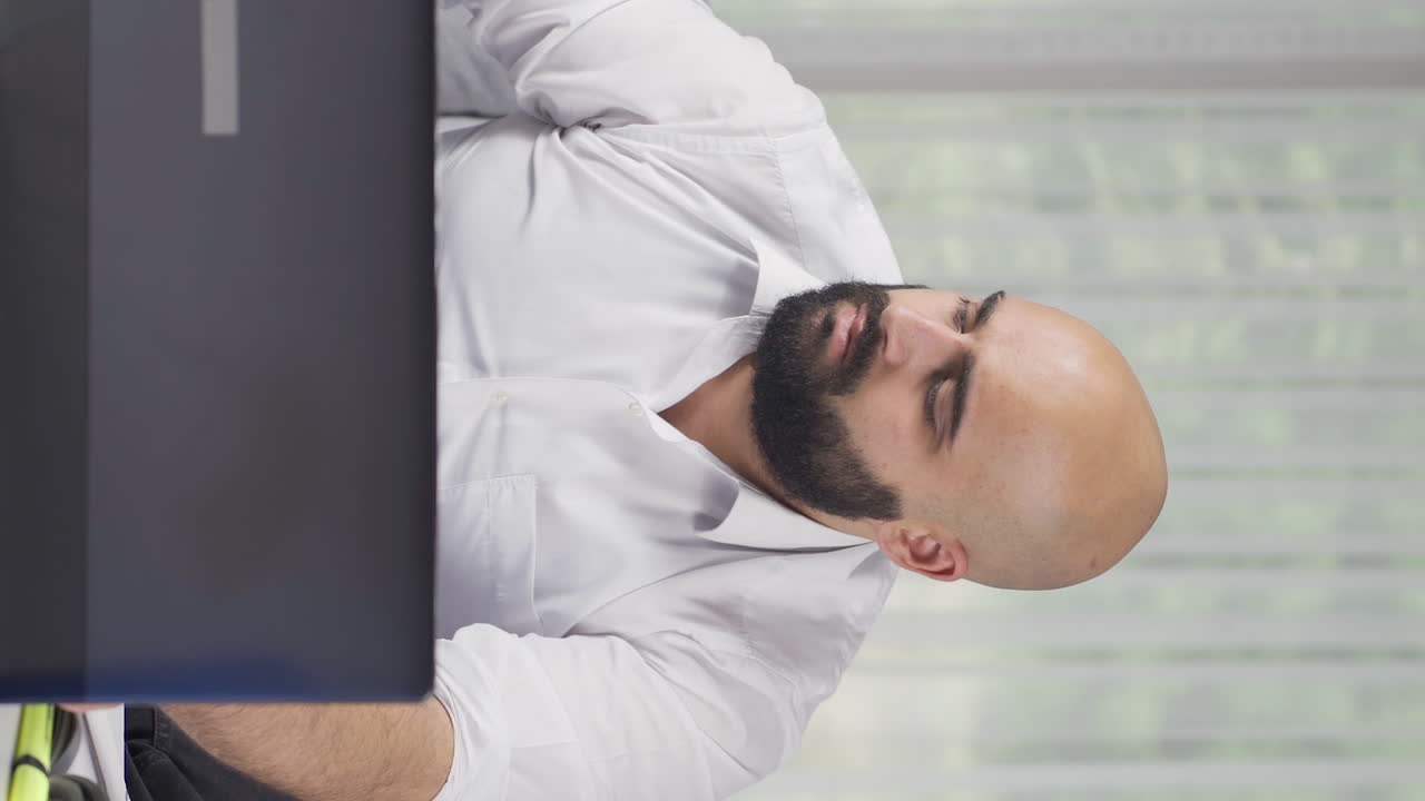 홈 오피스 직원의 수직 비디오가 전화로 좋은 소식을 듣고 있습니다.