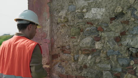 builder doing measurements on the old building outdoor