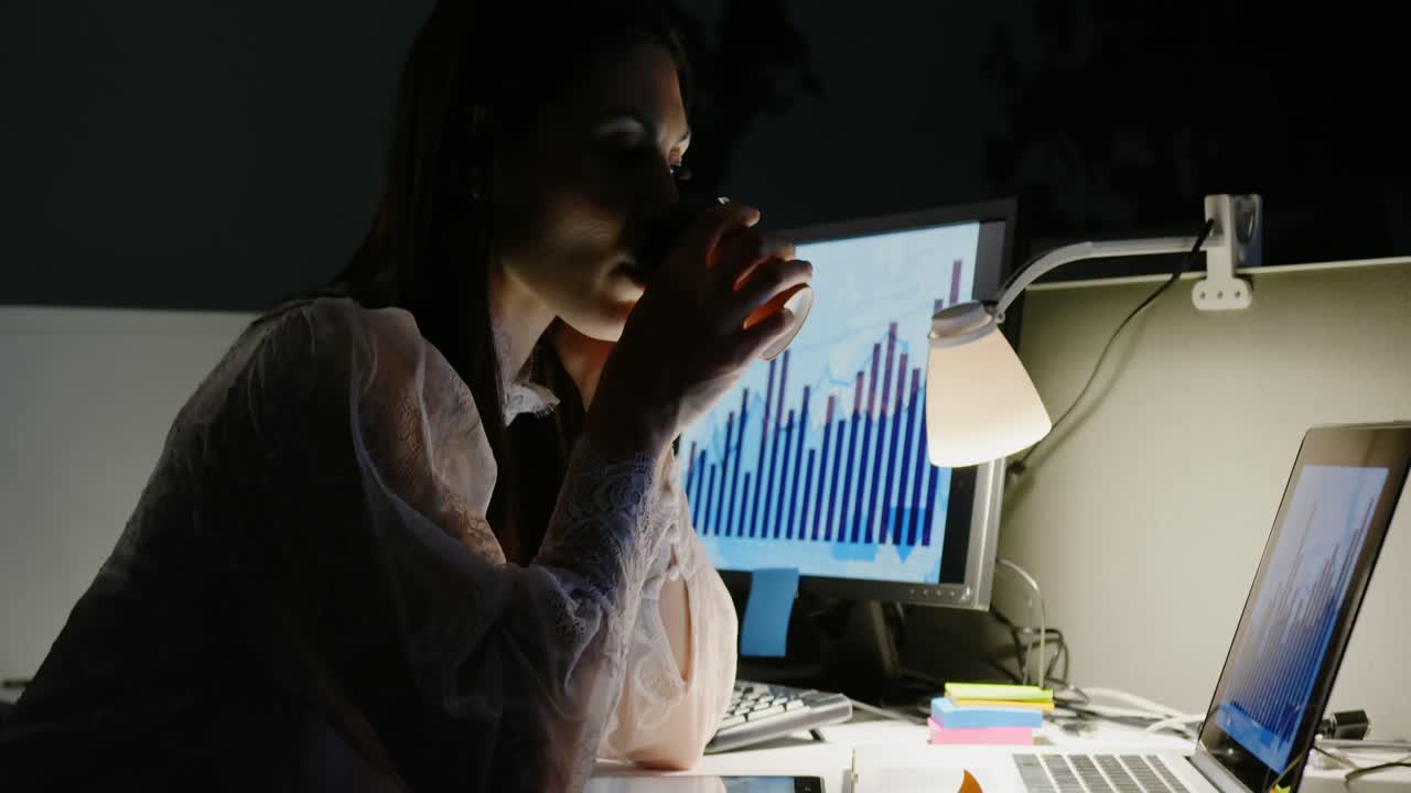 vista lateral de una joven ejecutiva caucásica trabajando en una computadora portátil en un escritorio en una oficina moderna 4k