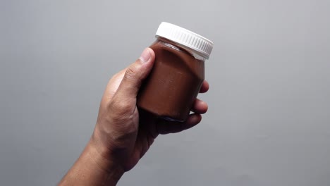 hand holding a jar of chocolate spread