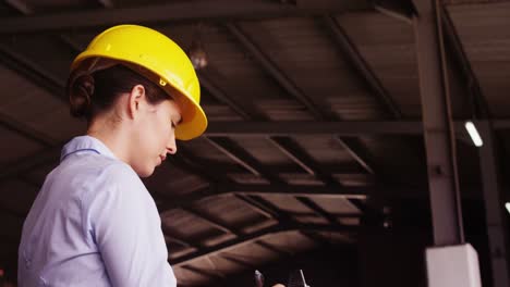 Female-supervisor-maintaining-record-on-clipboard