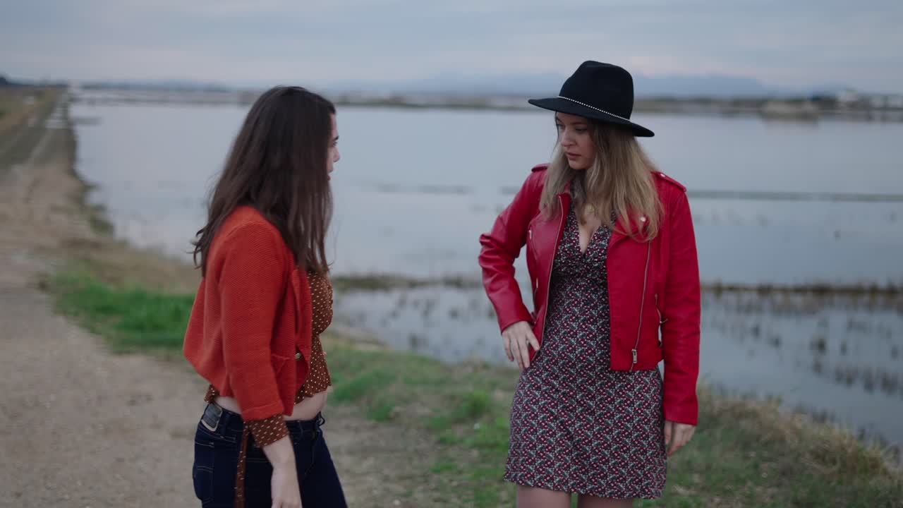 두 여인이 야외에서 대화하고 있습니다.