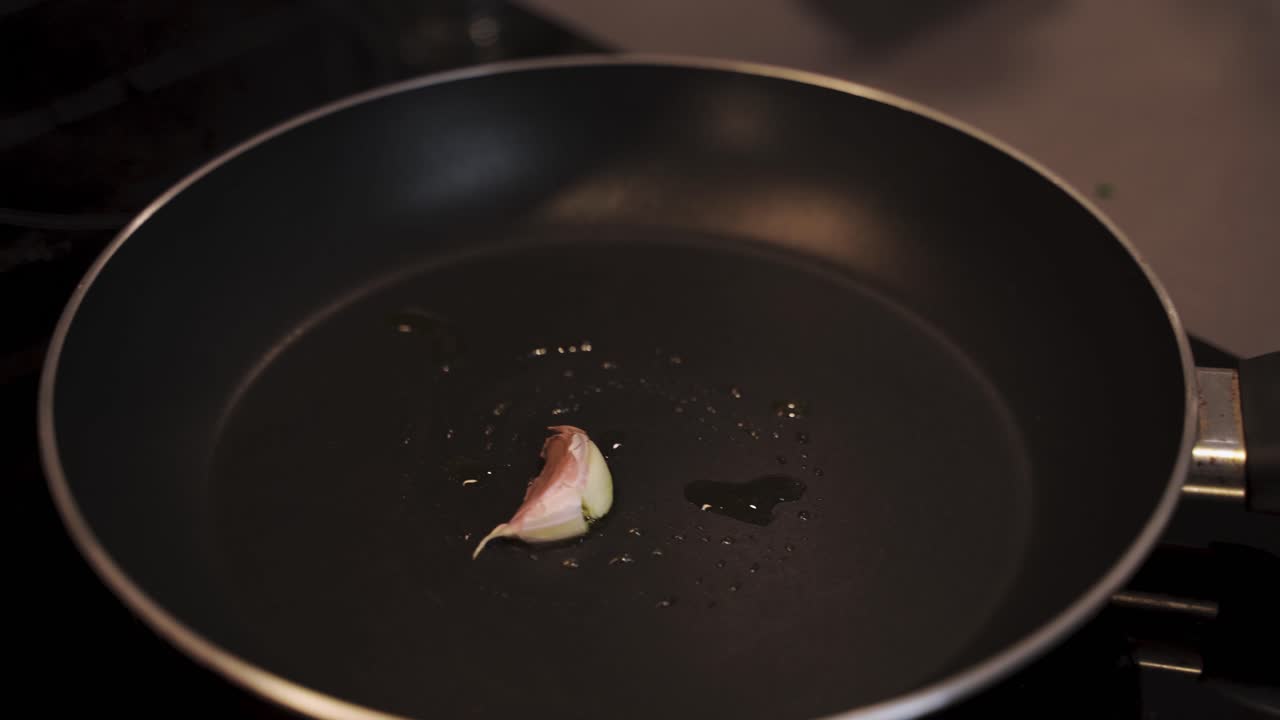 Chef strofina la superficie calda della padella con uno spicchio d'aglio.