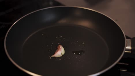 Chef-rubs-hot-pan-surface-with-garlic-glove
