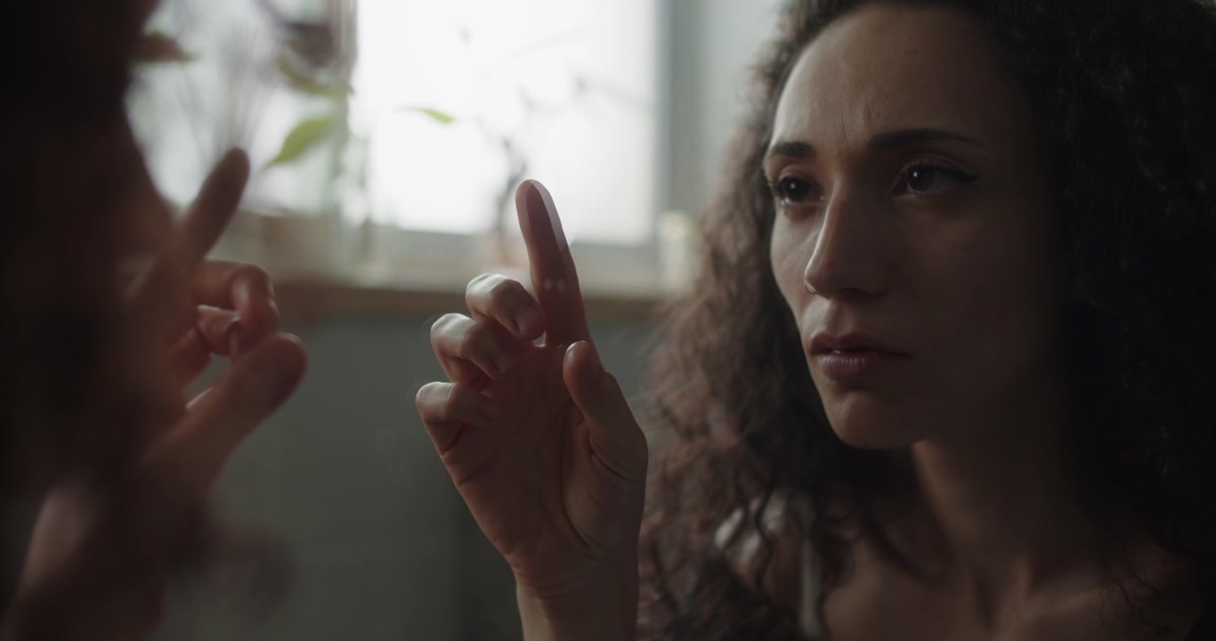 Woman touching reflection with a finger