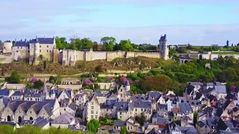 aerial clip of the historic riverside village overshadowed by large chateau chinon