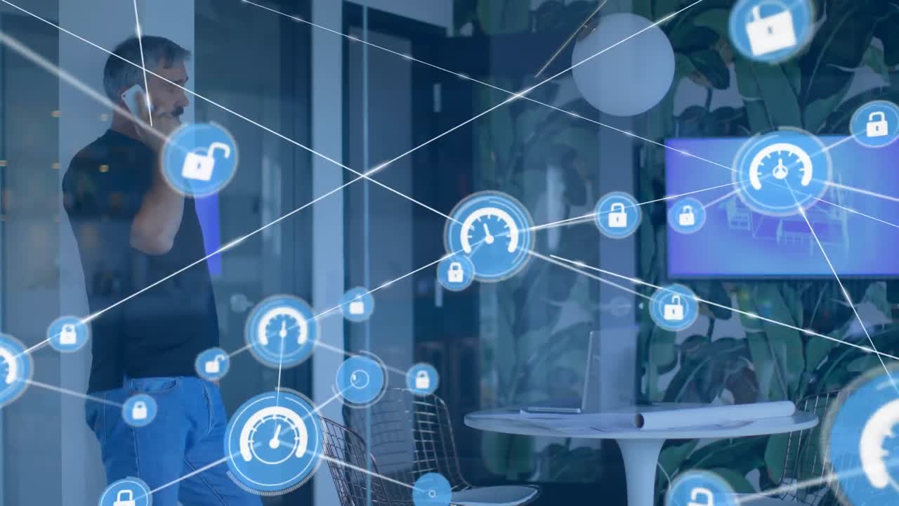 Animation of network of digital icons against biracial man talking on smartphone at office