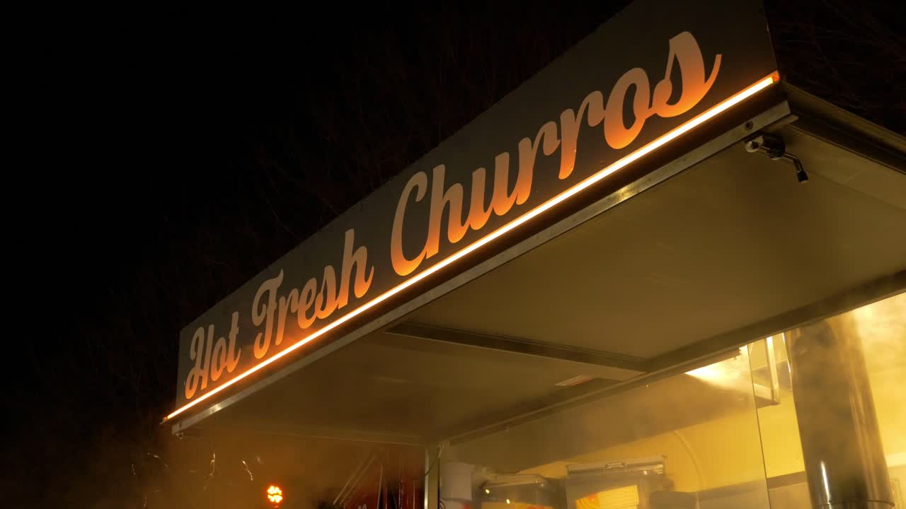 Market stall selling Hot Fresh Churros at night