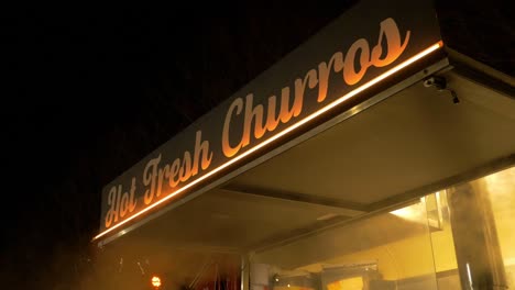 market stall selling hot fresh churros at night