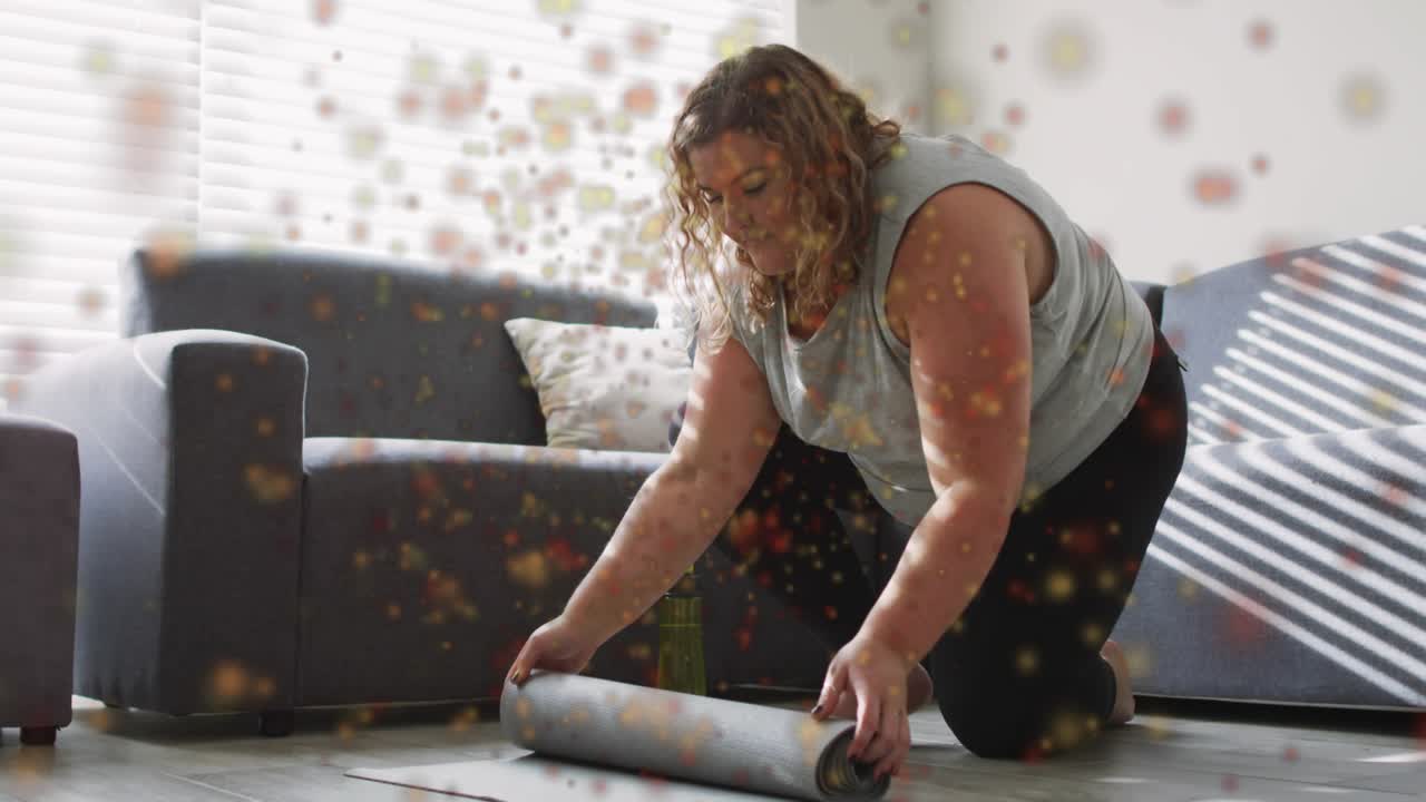 Woman entering living room kneeling near couch, unrolling yoga mat for fitness smoothing creases