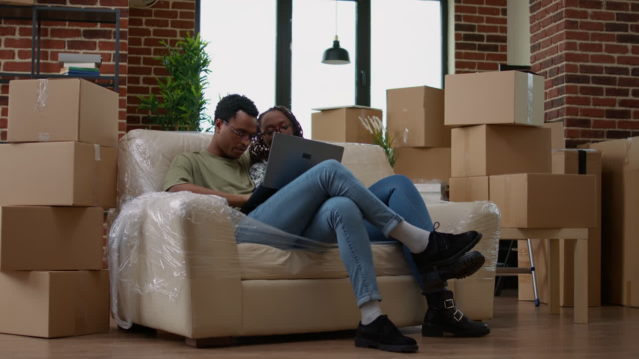 Married couple buying furniture online on laptop to decorate