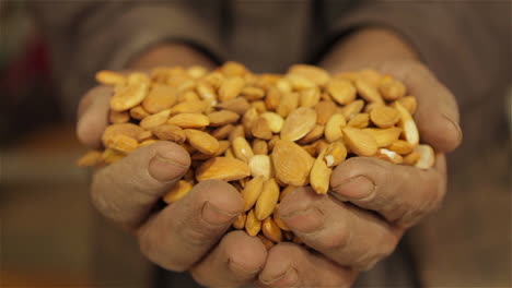 Manos-Sostienen-Almendras-Secas-En-Una-Fábrica-En-Afganistán