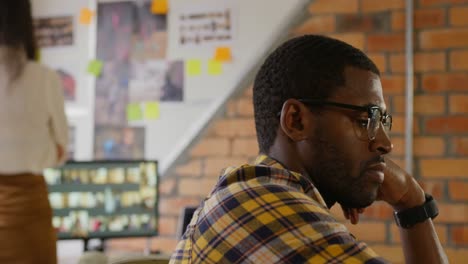 male graphic designer working at desk in a modern office 4k