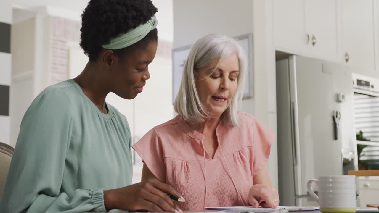 Happy senior caucasian woman with african american female friend talking
