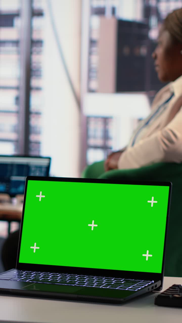 Laptop with Green Screen Display in Modern Office Setting