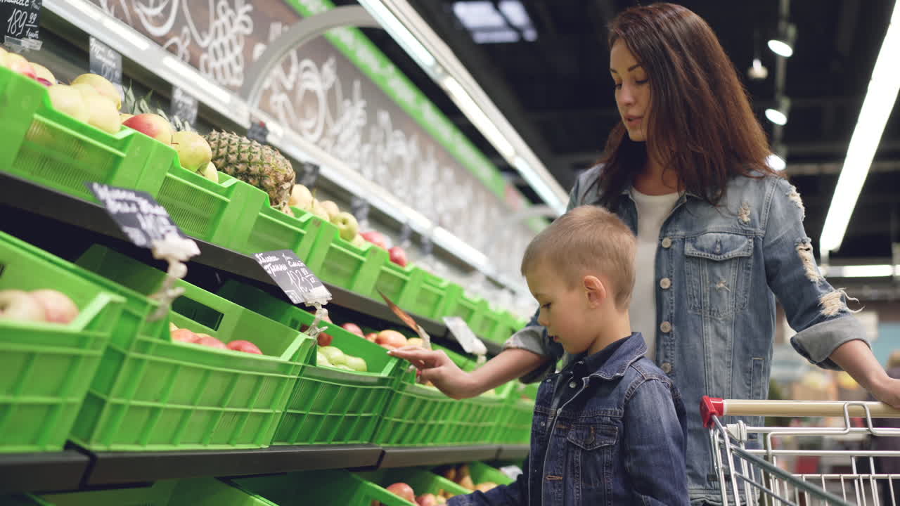 Mother and son shopping for fruits at the supermarket