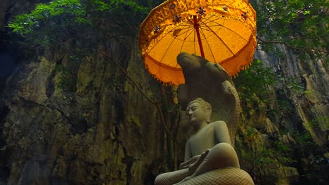 incense smoke rising to a stone statue and chatra or golden parasol in vajrayana buddhism