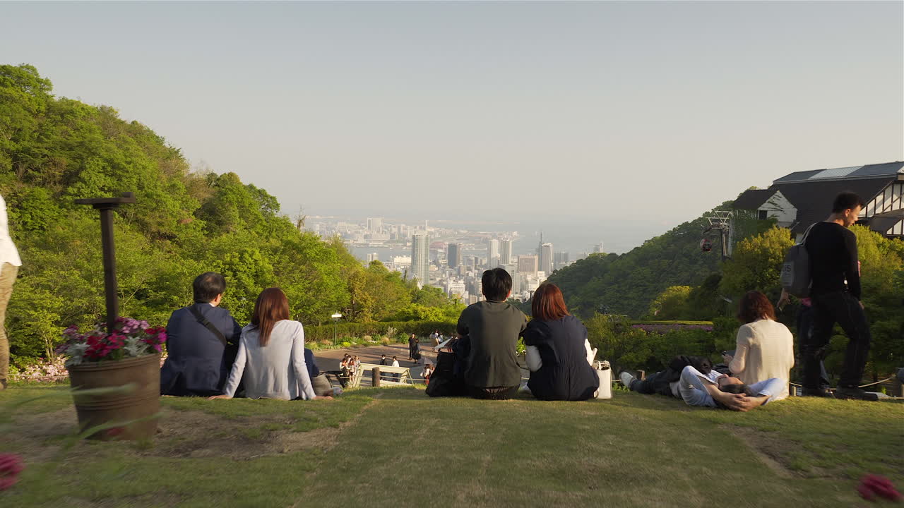 People sitting on grass at Kobe's Nunobiki garden