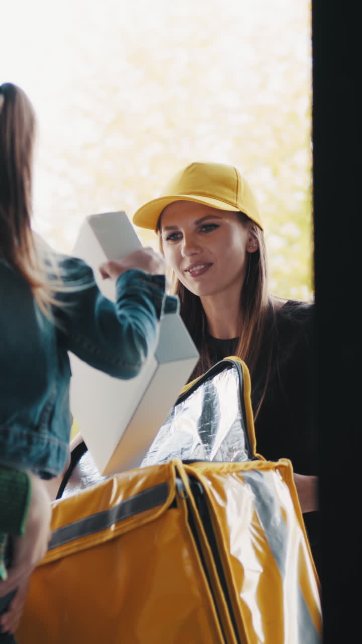 Smiling delivery woman with a yellow cap and bag