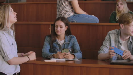 el grupo de estudiantes felices y alegres sentados en una sala de conferencias antes de la lección
