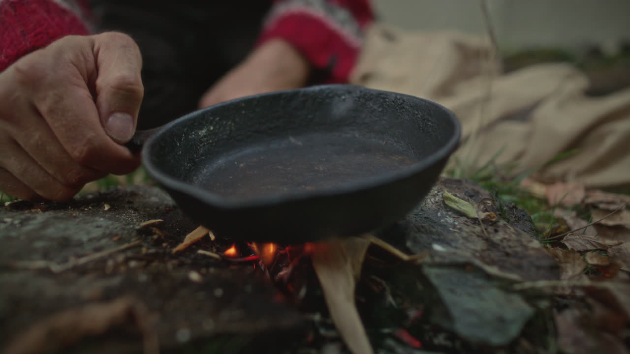 Hands of Tourist Making Campfire and Placing Cast Iron Pan On It for Cooking