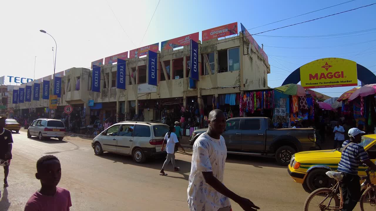 Traffic and people in front of the entrance to the Serrekunda Market in Gambia