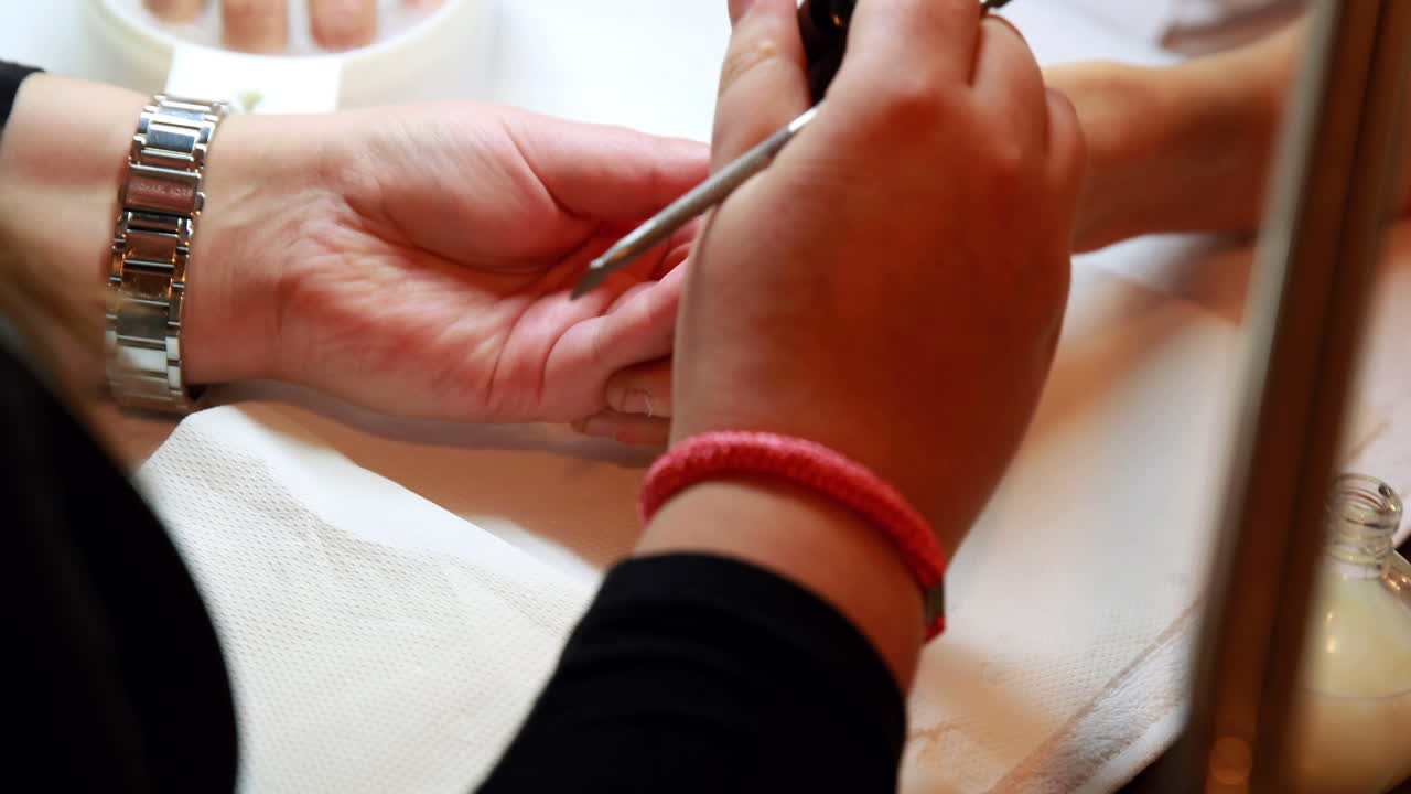 técnico de uñas dando a un cliente una manicura