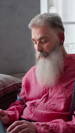 older man with long white beard in pink shirt
