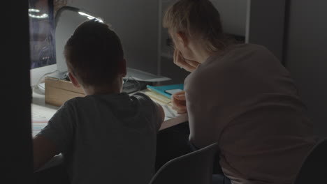 mom helps son with studying during covid-19 quarantine