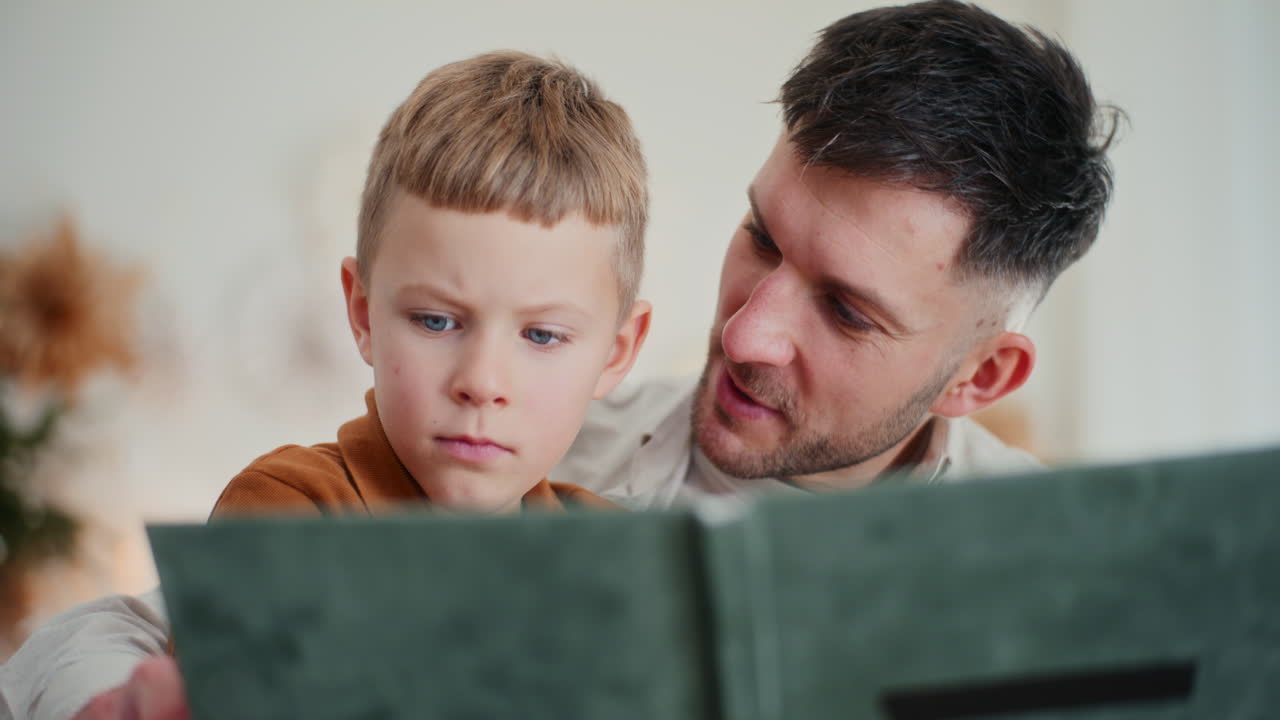 un padre y su hijo pasan las vacaciones en un ambiente familiar mirando fotos familiares