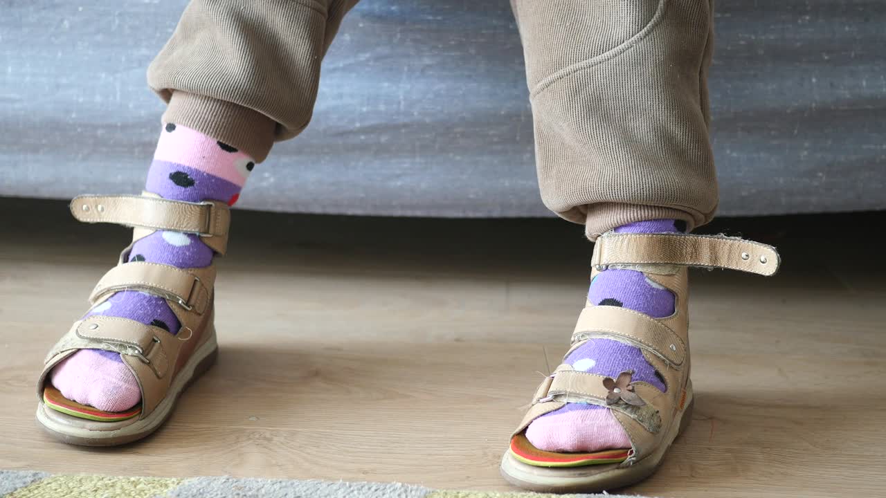 Barn iklädd ortopediska sandaler och strumpor