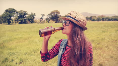 gelukkige hipster drinkt bier in het park.