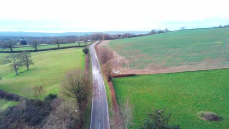 aerial view over main road by a house and farmland