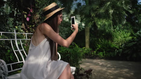 una mujer tomando una selfie en un invernadero.